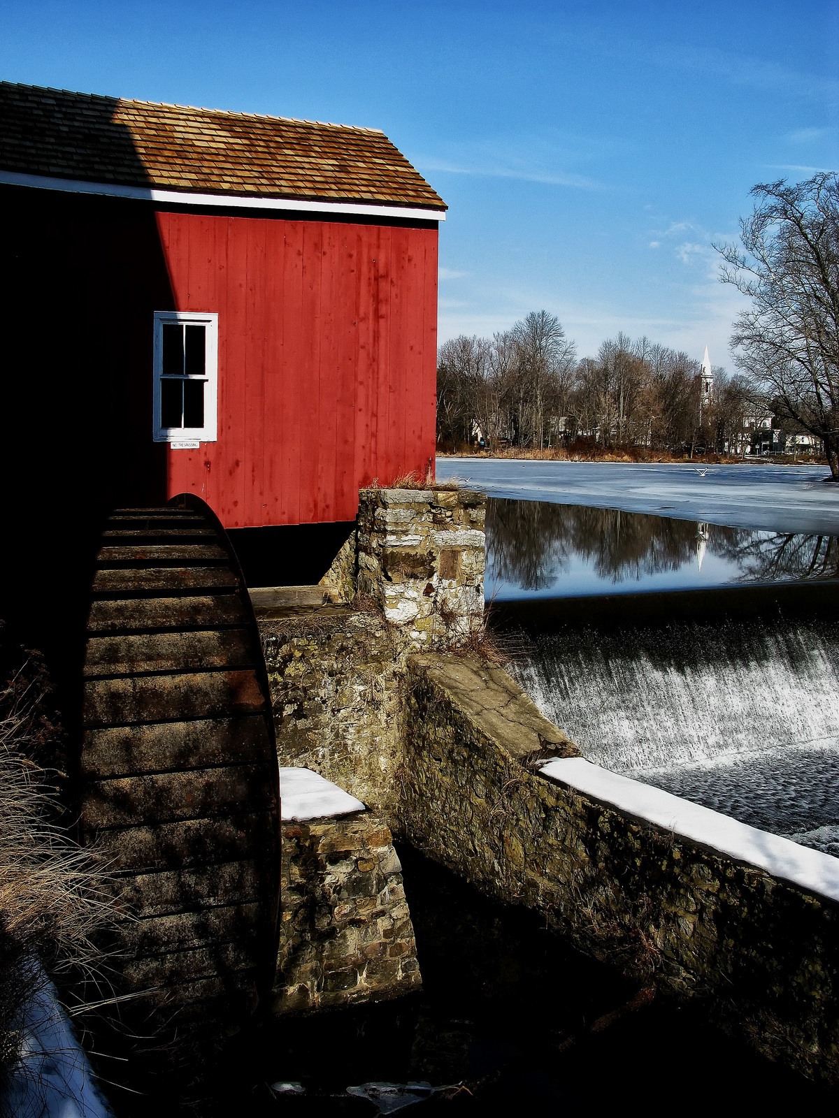 A small window of the past reflects in the water above the mill.