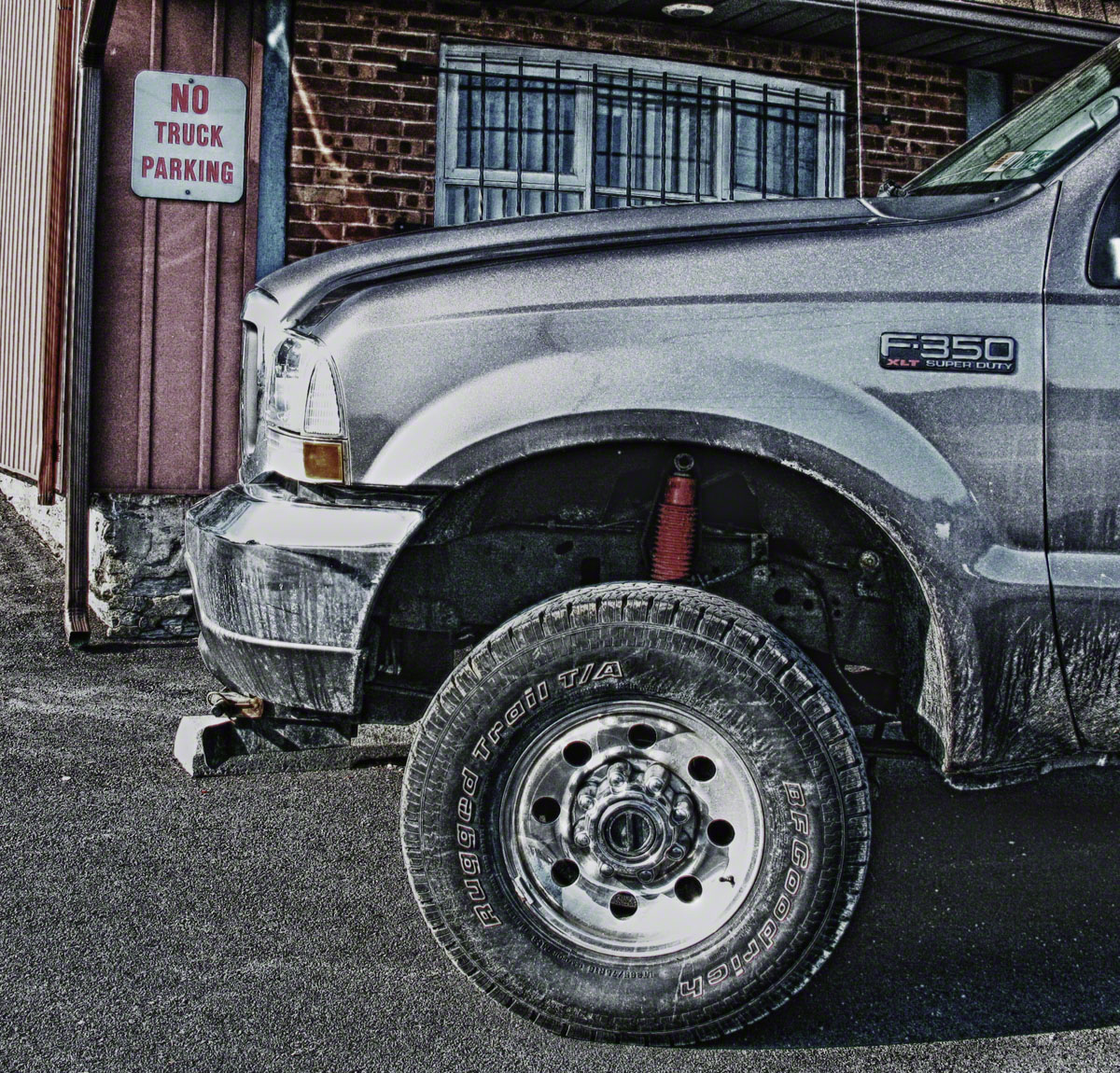 One large Ford Truck feeling out of place in this small parking space.