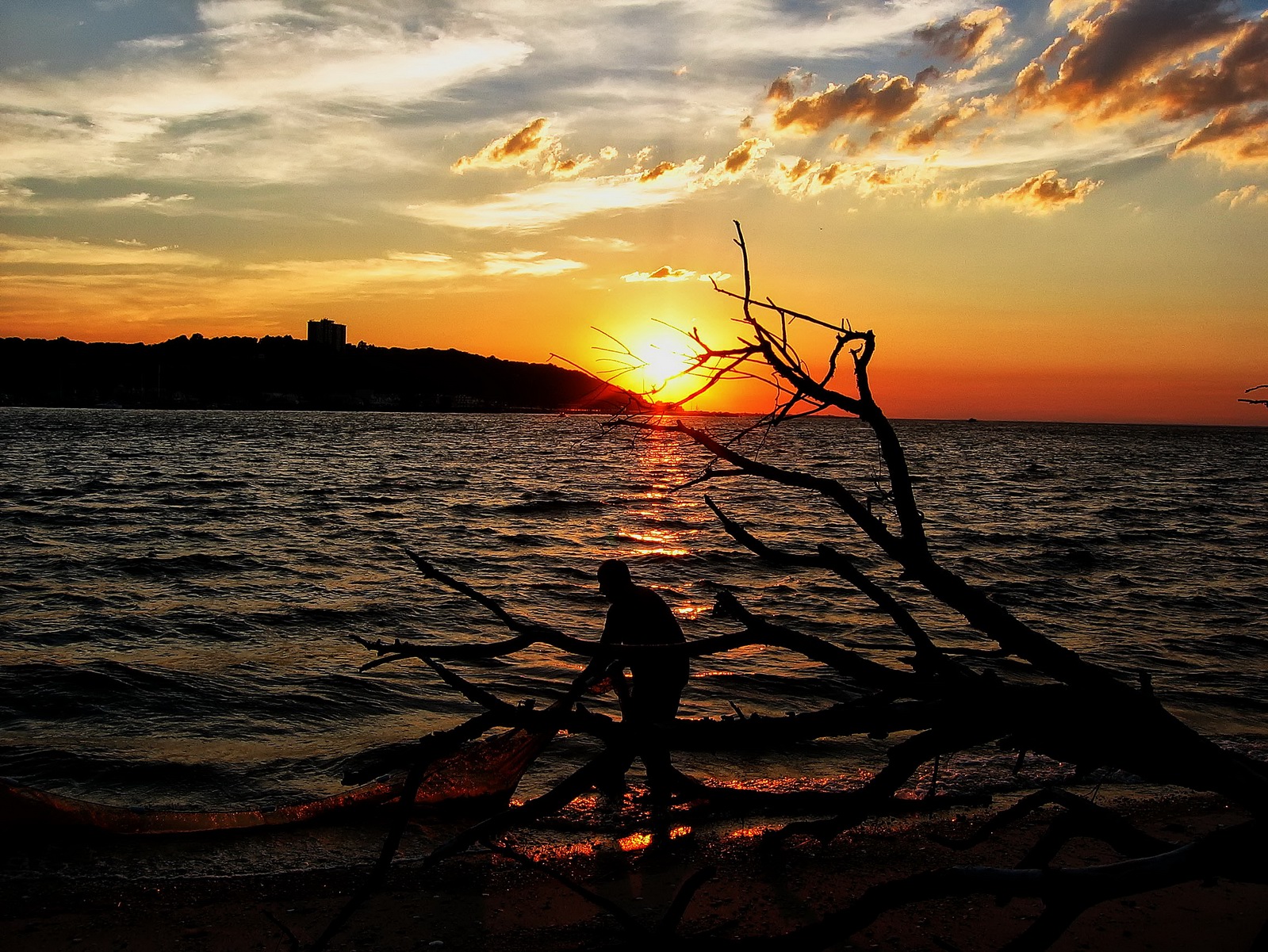 The suns golden rays surround the fishermens silhouette.